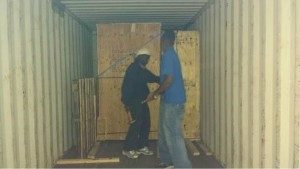 Movers securing crates in storage unit