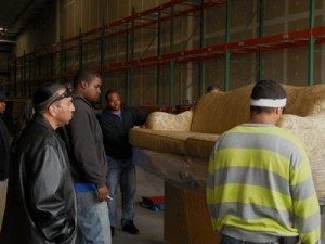 Movers handling furniture in storage warehouse